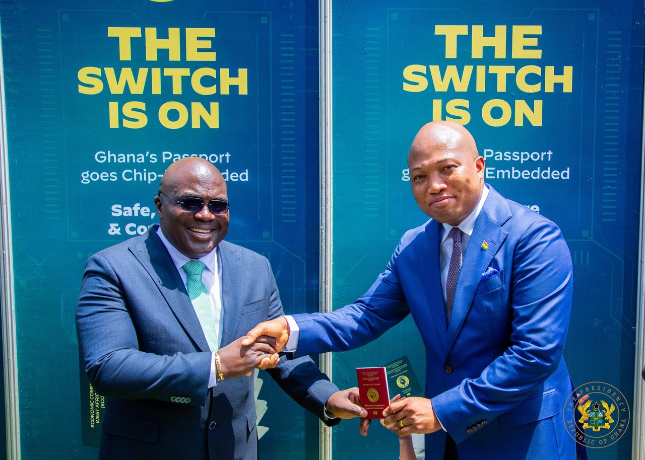 Chief of Staff, Julius Debrah (L), receives his chip-embedded passport from Foreign Affairs Minister, Samuel Okudzeto Ablakwa (R)