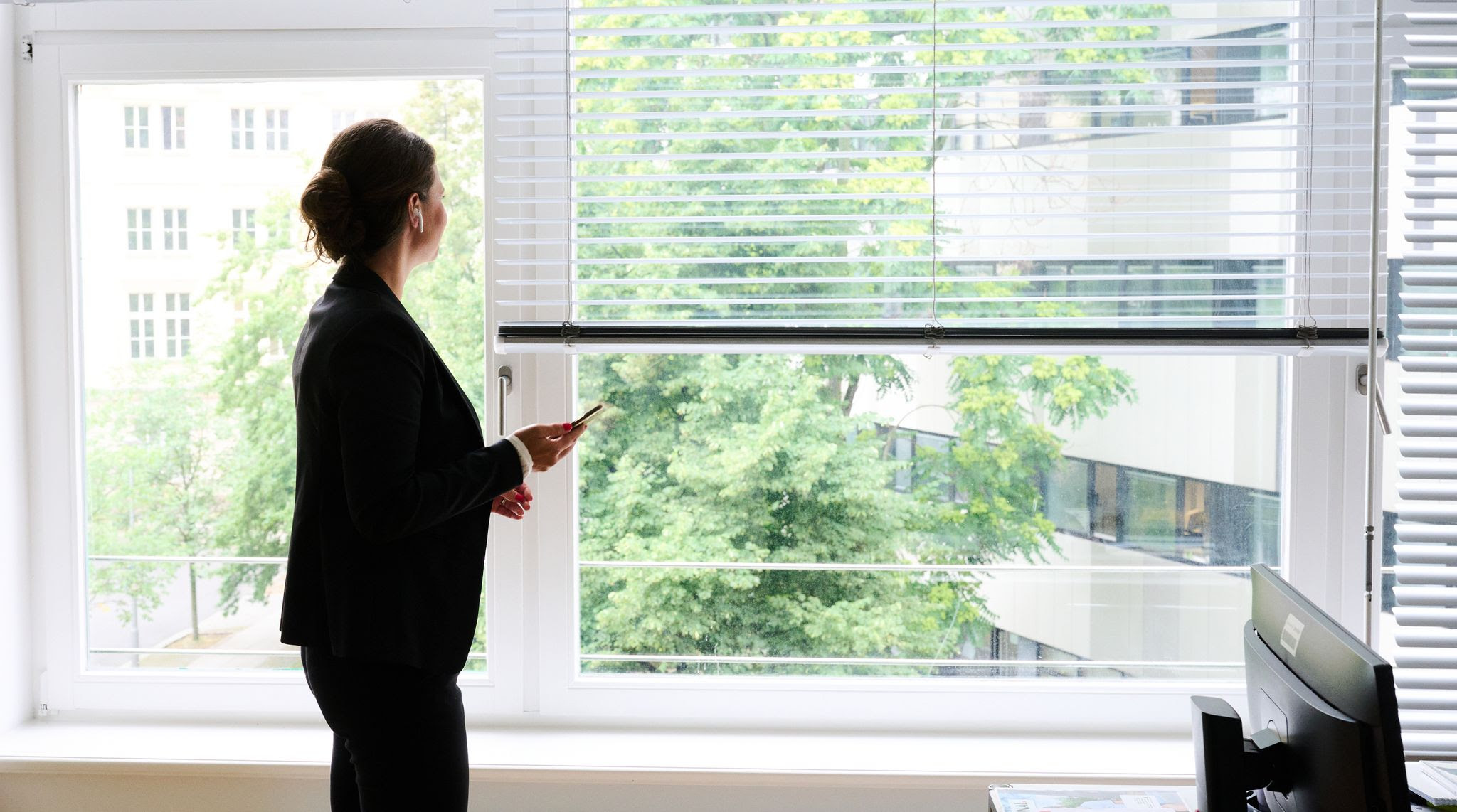 A woman stands in an office by a window and makes a phone call using a headset. The proportion of women in top management and supervisory boards at Germany's largest companies has reached record levels, according to a new analysis by the organization Women in Supervisory Boards (Fidar), which was provided to dpa.