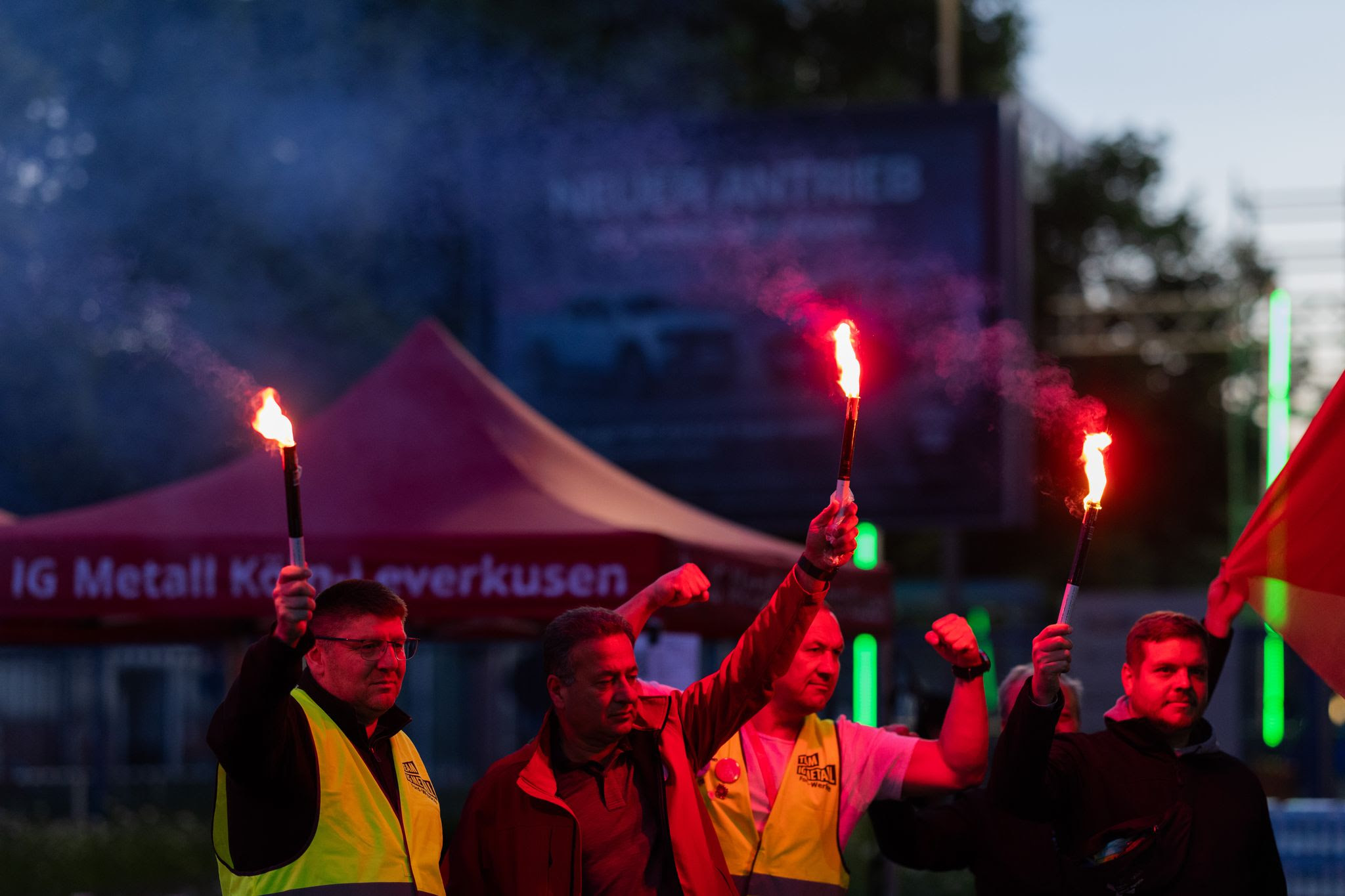 Employees with burning torches stand in front of the Ford plants in Cologne during the first strike. A strike is taking place for the first time at the Ford plants in Cologne. The protest action against planned job cuts at the site with 11,500 employees is to begin on Wednesday morning and last until the end of the night shift on Thursday morning, according to IG Metall.