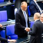 Acting Federal Chancellor Olaf Scholz shakes hands with Chancellor candidate Friedrich Merz during the second round of Chancellor election. Merz failed the first round of voting in the Bundestag.