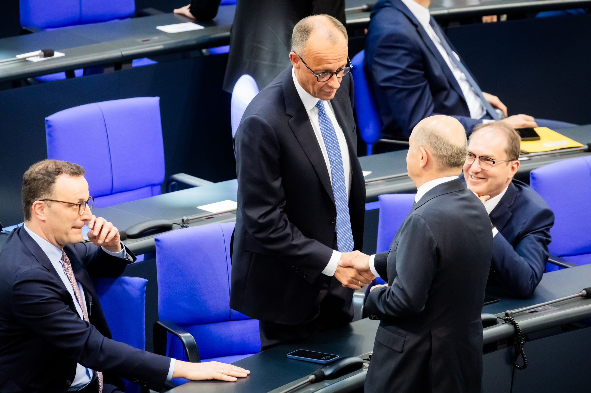 Acting Federal Chancellor Olaf Scholz shakes hands with Chancellor candidate Friedrich Merz during the second round of Chancellor election. Merz failed the first round of voting in the Bundestag.