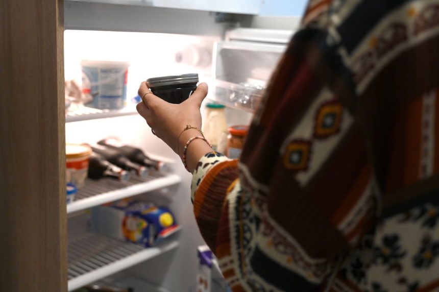 FILED - 03 July 2024, Berlin: A woman takes a jar of jam out of the fridge at home. Roughly 17 million people in Germany were living alone last year, or more than one in five, according to data from the Federal Statistical Office released on Wednesday.