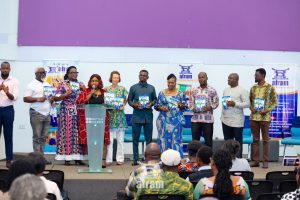 Rebecca Ekpe, GJA Vice President (in red print and with mic, launching book) with Author Margaretha Ubels, Publisher, Afram Publications rep. Madam Harriet Tagoe (in glasses) and other dignitaries).