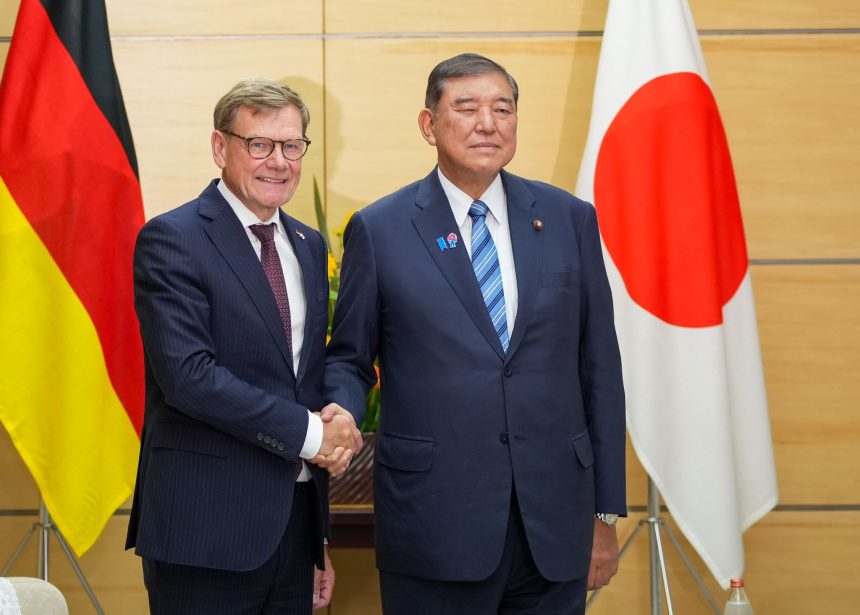 German Foreign Minister Johann Wadephul (L) and Japan's Prime Minister Shigeru Ishiba (R) greet each other before their talks.