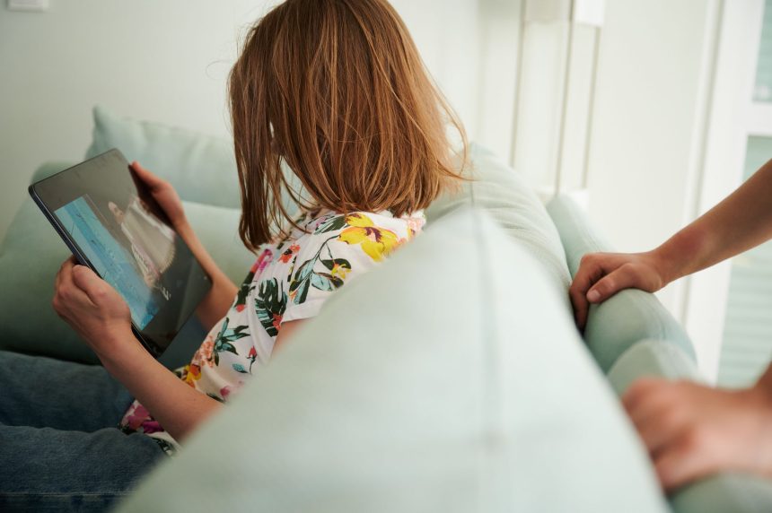 28 May 2022, Berlin: A child looks at a tablet. More than three-quarters of parents of teenage children in Germany are stressed, a survey found on Tuesday.
