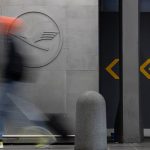 29 September 2025, Hesse, Frankfurt/Main: A man walks in front of a Lufthansa logo at Frankfurt Airport. Company sources have revealed that the Group intends to cut a fifth of its administrative jobs in the coming years. The Executive Board intends to present its comprehensive plans for staff cuts in more detail this Monday. Photo: Hannes P. Albert/dpa