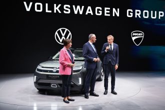 German Chancellor Friedrich Merz (C) and German Association of the Automotive Industry (VDA) President Hildegard Mueller stand at the Volkswagen Group stand with VW CEO Oliver Blume during the opening of the IAA Mobility international motor show. Photo: Sven Hoppe/dpa