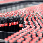 Coca-Cola glass bottles are transported on a conveyor belt at the Mannheim production site of Coca-Cola Europacific Partners - CCEP Deutschland GmbH. Photo: Uli Deck/dpa
