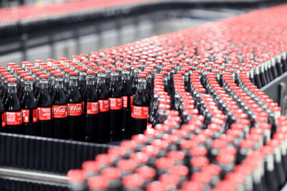 Coca-Cola glass bottles are transported on a conveyor belt at the Mannheim production site of Coca-Cola Europacific Partners - CCEP Deutschland GmbH. Photo: Uli Deck/dpa