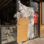 14 November 2025, Turkey, Istanbul: A cardboard and plastic sheeting hang next to a Turkish flag at a Turkish street food stall that was closed by the Turkish authorities, after the deaths of the three and six-year-old children, the German mother also died in hospital, as the DHA news agency reported. Photo: Ahmed Deeb/dpa