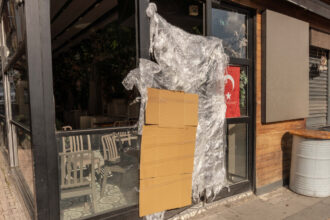 14 November 2025, Turkey, Istanbul: A cardboard and plastic sheeting hang next to a Turkish flag at a Turkish street food stall that was closed by the Turkish authorities, after the deaths of the three and six-year-old children, the German mother also died in hospital, as the DHA news agency reported. Photo: Ahmed Deeb/dpa