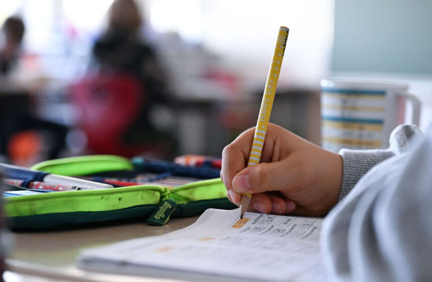 In an elementary school, a fourth-grade student is working on his math problems in a notebook. Photo: Bernd Weißbrod/dpa