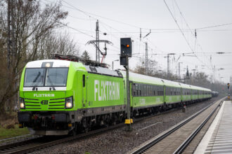 22 March 2024, Brandenburg, Trebbin: A Flixtrain passes Trebbin station. Photo: Soeren Stache/dpa