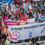 06 April 2026, Hamburg: People hold a large banner during the Easter march under the motto "Not our war!". The annual Easter march was organized by the Hamburg Forum for International Understanding and Global Disarmament. Photo: Markus Scholz/dpa
