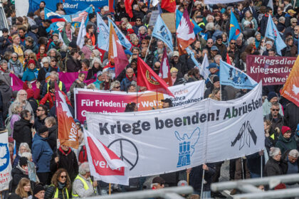 06 April 2026, Hamburg: People hold a large banner during the Easter march under the motto "Not our war!". The annual Easter march was organized by the Hamburg Forum for International Understanding and Global Disarmament. Photo: Markus Scholz/dpa