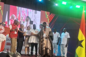 Dr. Donkoh, (in White Fugu), receiving Red Cross Report at World Red Cross Celebration in Accra.