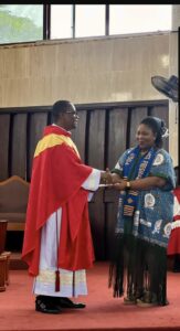 Mrs. Ruby Martha Tawiah, President of POGA, Tema branch making a presentation to Fr. Hessah.