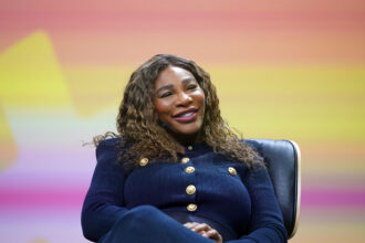 Former US tennis player Serena Williams sits on stage at the OMR digital trade show in the exhibition halls. Credit: Marcus Brandt/dpa