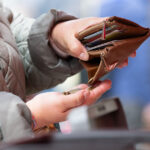 A woman holds an open wallet at a weekly market. Photo: Sebastian Kahnert/dpa