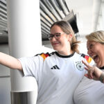 02 June 2026, Hesse, Frankfurt/Main: German football fans Leonie (L) and Anja Michalek pose for a photo with German national team shirts at Frankfurt Airport. The two passengers are flying to Chicago on the same aircraft as the German men's national football team and were presented with the shirts by the airline at the departure gate. Photo: Federico Gambarini/dpa - IMPORTANT NOTE: In accordance with the regulations of the DFL German Football League and the DFB German Football Association, it is prohibited to utilize or have utilized photographs taken in the stadium and/or of the match in the form of sequential images and/or video-like photo series.