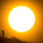 A walker stands in front of the setting sun near Hanover in northern Germany. Photo: Julian Stratenschulte/dpa