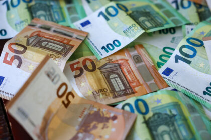 FILED - Several 100- and 50-euro banknotes are lying on a table. Photo: Jan Woitas/dpa